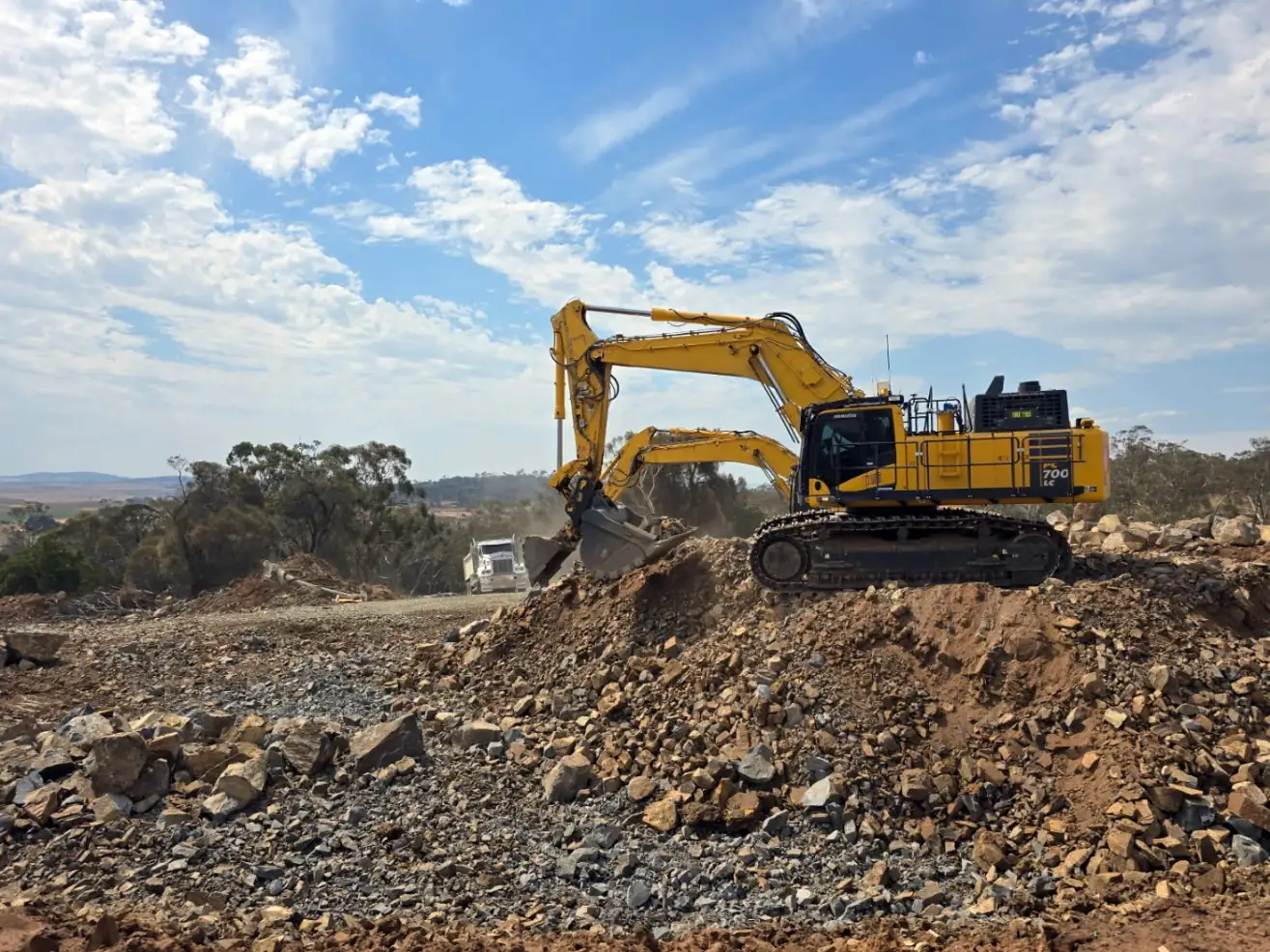 Excavator working broken rock on a Tasmanian civil earthworks site
